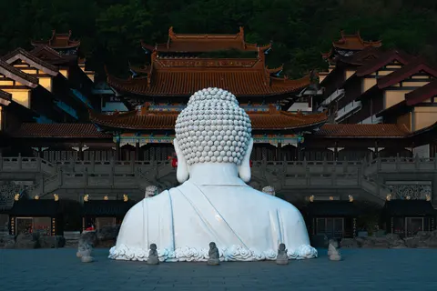 一尊白色雕像面对着寺庙