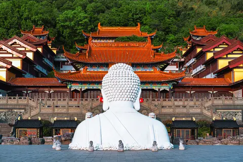 一尊白色雕像面对着寺庙