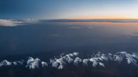 天际微光下，雪山与云海交叠